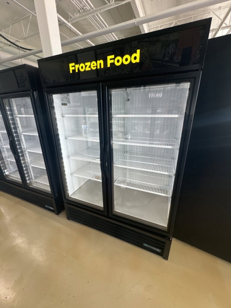 An empty commercial frozen food display freezer, representing equipment serviced by Setpoint Refrigeration LLC in Liberty Hill, TX