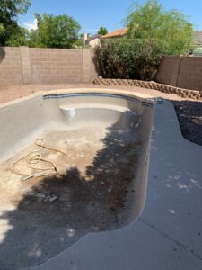 An empty and dirty swimming pool, indicating a need for renovation or cleaning services from East Mesa Pools, LLC in Mesa, AZ.
