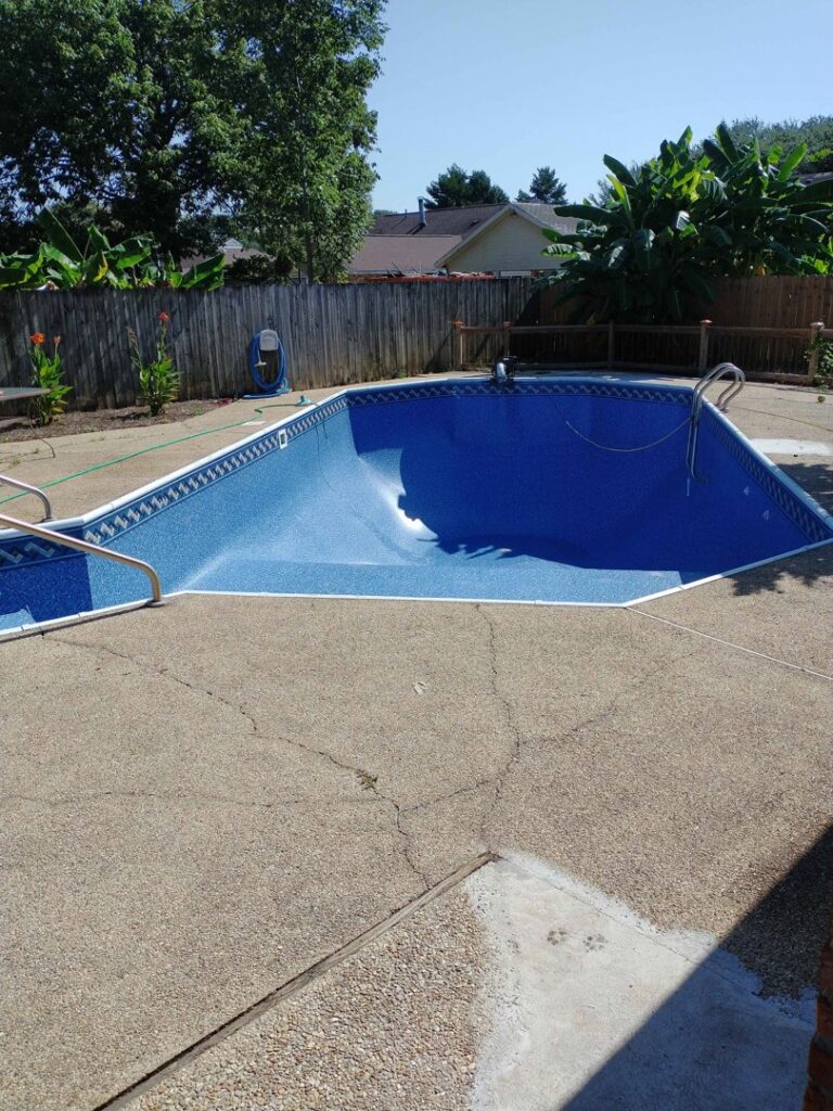 An empty, newly lined pool with a unique curved shape, showcasing liner installation by Brian's Pool Service in Baton Rouge, LA.