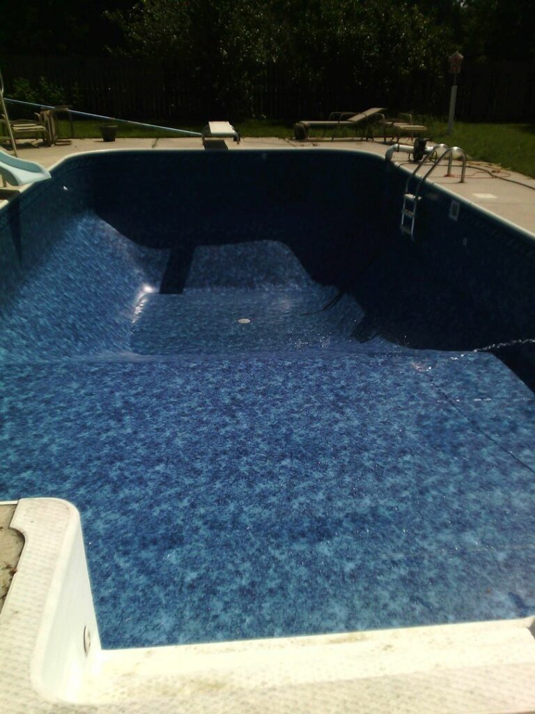 An empty, newly lined pool with a distinct geometric shape, showing liner installation by Brian's Pool Service in Baton Rouge, LA.