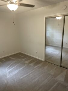 An empty room with a freshly cleaned carpet showing vacuum lines by Wilmington Carpet Cleaning NC in Wilmington, NC.