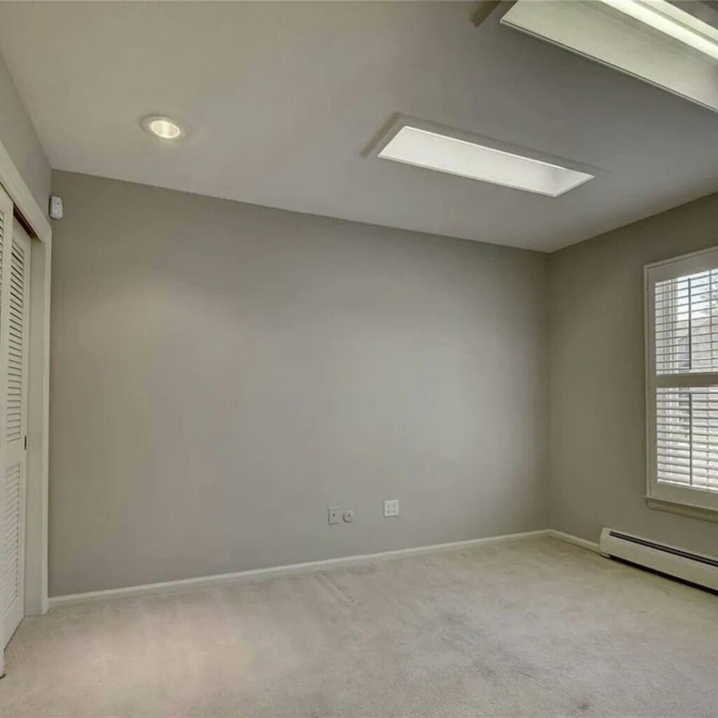 A clean, empty room featuring a fresh light-colored carpet installation by Floors By Tomorrow in Aurora, CO