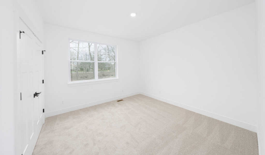 A newly carpeted empty room, showcasing professional carpet installation by Duke Brothers Oriental Rug Cleaning in Norfolk, VA.