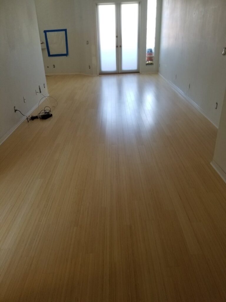 An empty room featuring newly installed light wood flooring, a completed project by LACarpetWarehouse in Los Angeles, CA.