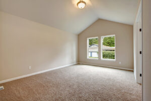 An empty room showcasing new light brown wall-to-wall carpet, a service provided by United Carpet in Rochester, NY.