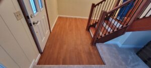 An entryway featuring newly carpeted stairs and hardwood flooring by Lakefront Flooring in Erie, PA.