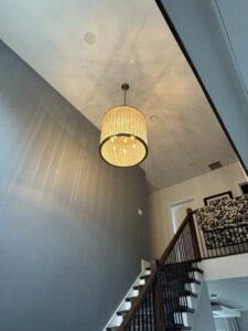 An entryway with a large chandelier and recessed lighting installed by Ramos Electrical services inc in Brownsville, TX