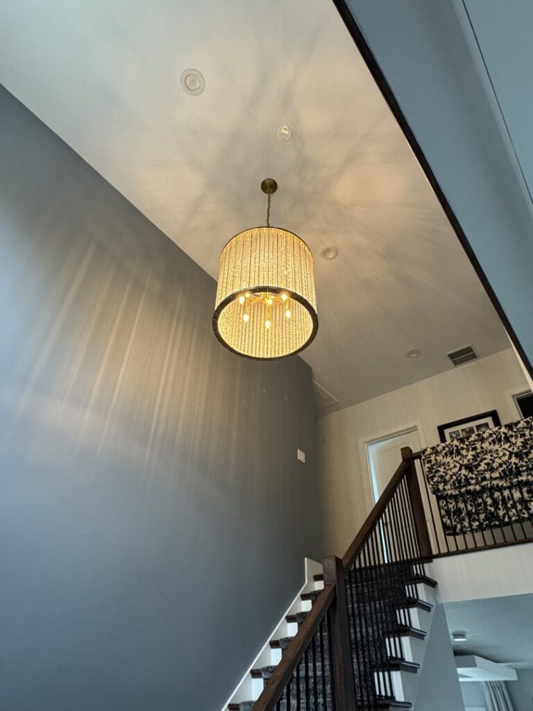 An entryway with a large chandelier and recessed lighting installed by Ramos Electrical services inc in Brownsville, TX