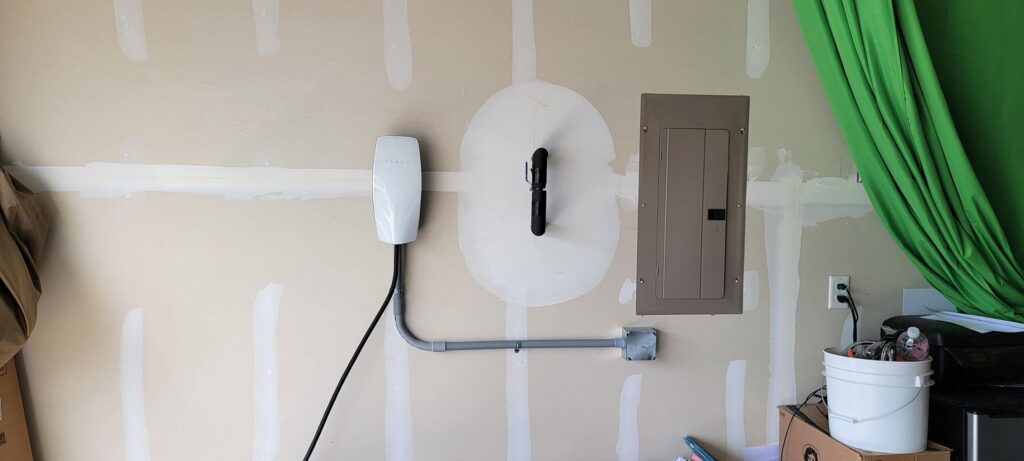 Electric vehicle charger and electrical panel installed on a garage wall by Lindsey and Son Electric, LLC in Summerville, SC