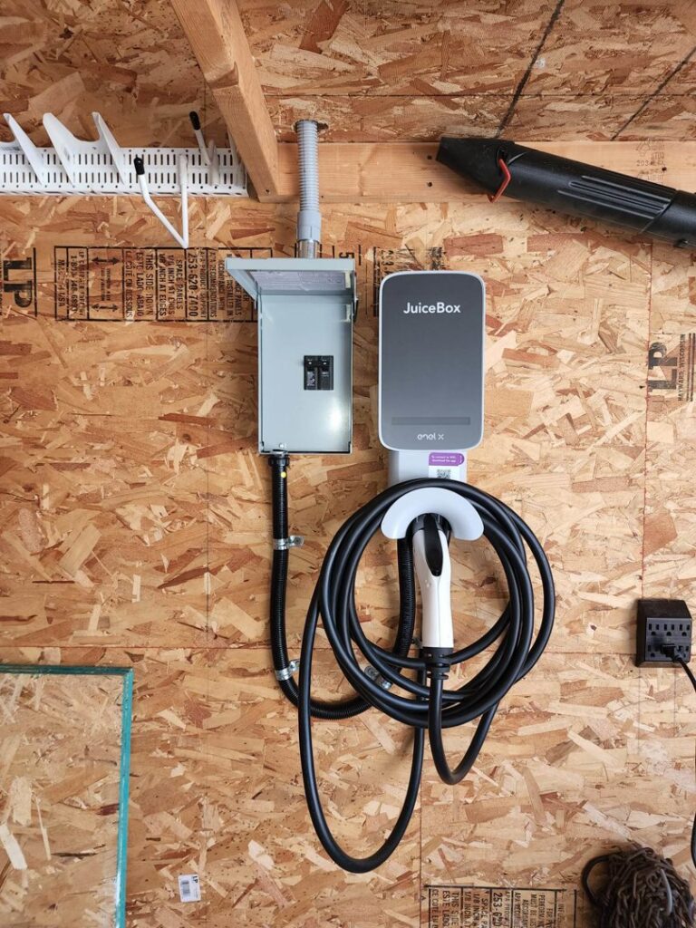 An EV charger (JuiceBox) and associated electrical panel installed in a garage by Apparent Electric LLC in Oshkosh, WI.