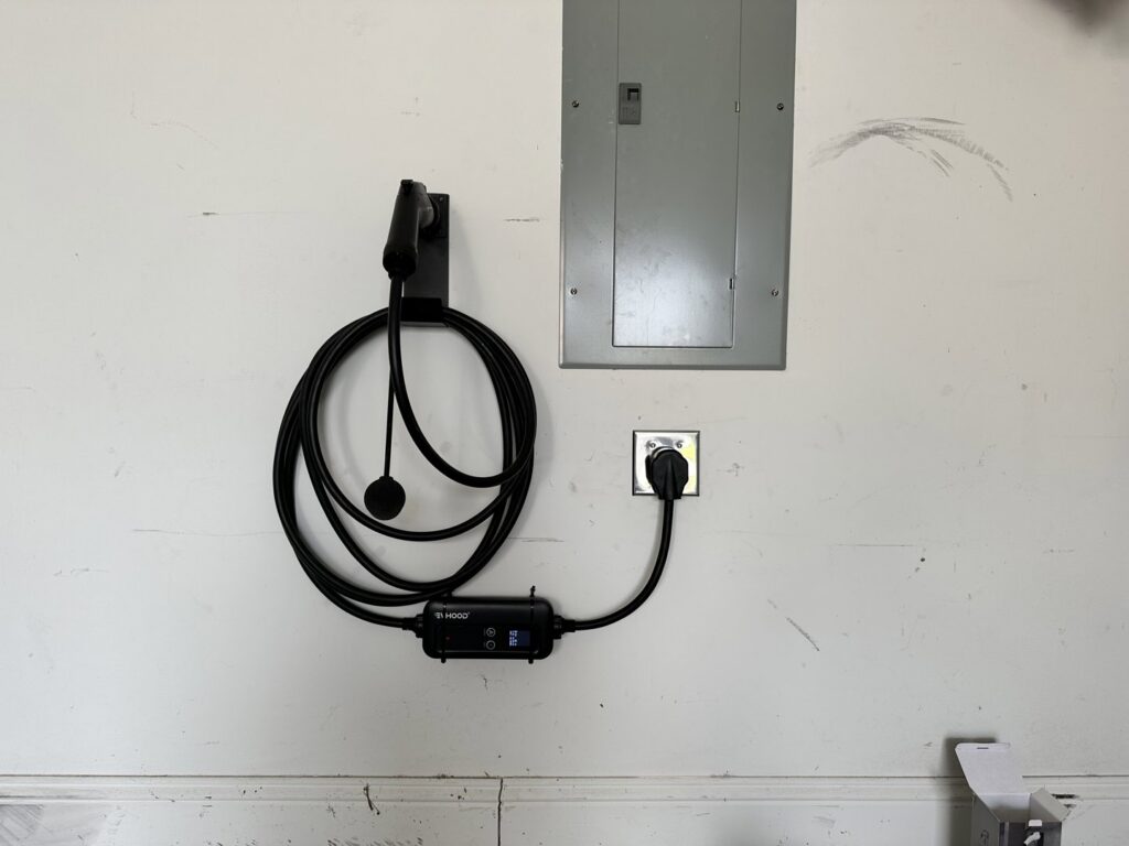 An electric vehicle (EV) charger installed in a garage, connected to a main electrical panel by Babcock Electric & Communications in Lake Charles, LA.