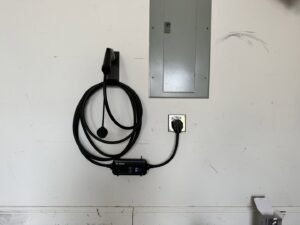An electric vehicle (EV) charger installed in a garage, connected to a main electrical panel by Babcock Electric & Communications in Lake Charles, LA.