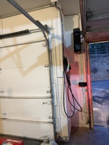 An EV charger professionally installed on a garage wall by ChargerPro in Denver, CO.