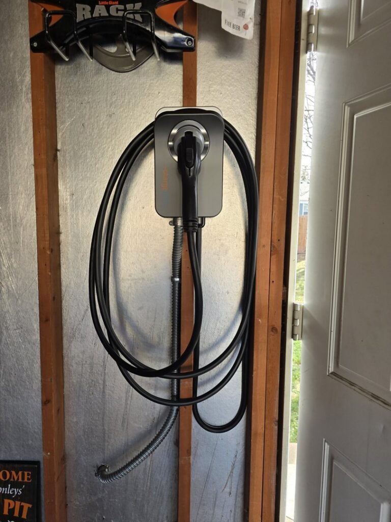 An EV charger professionally installed on a metal-clad wall by ChargerPro in Denver, CO.