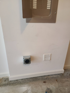 An EV charging outlet and electrical panel installed by Joe Does It-Electrical Services in Atlanta, GA.