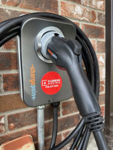 An EV charging station with a green light indicating use, installed by Clemens Electric in Averill Park, NY