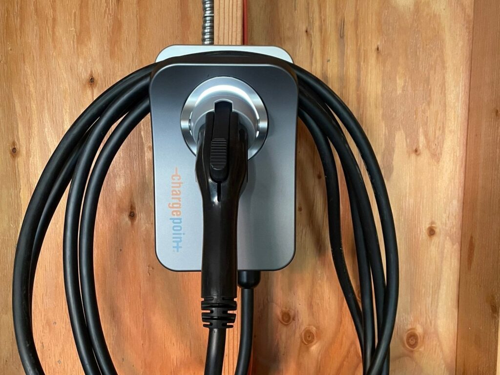 A ChargePoint electric vehicle charging station installed on a wooden wall, a service provided by Beaver Electric in Hillsboro, OR.