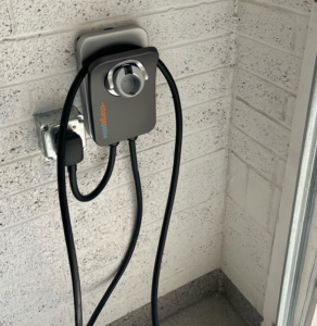A newly installed EV charging station on a brick wall, expertly set up by Desert Sun Electrical in Mesa, AZ.