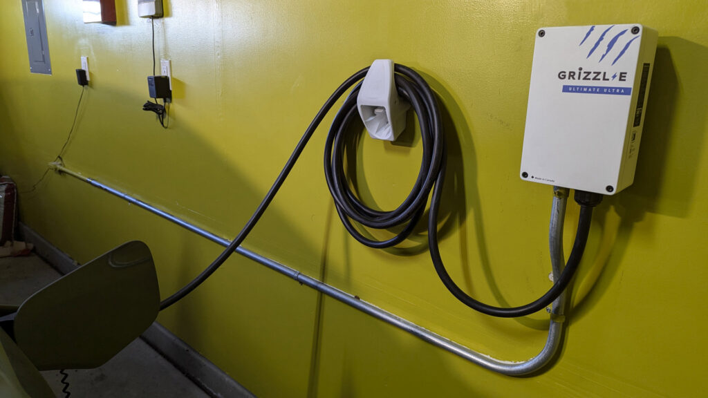 An installed Grizzl-E EV charging station on a yellow wall, a service by Electrical Power Source in Fresno, CA.