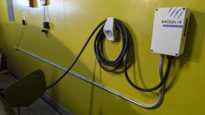 An installed Grizzl-E EV charging station on a yellow wall, a service by Electrical Power Source in Fresno, CA.