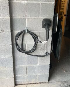 An installed electric vehicle charging station on a garage wall by Gloudeman Electric in Mount Pleasant, SC