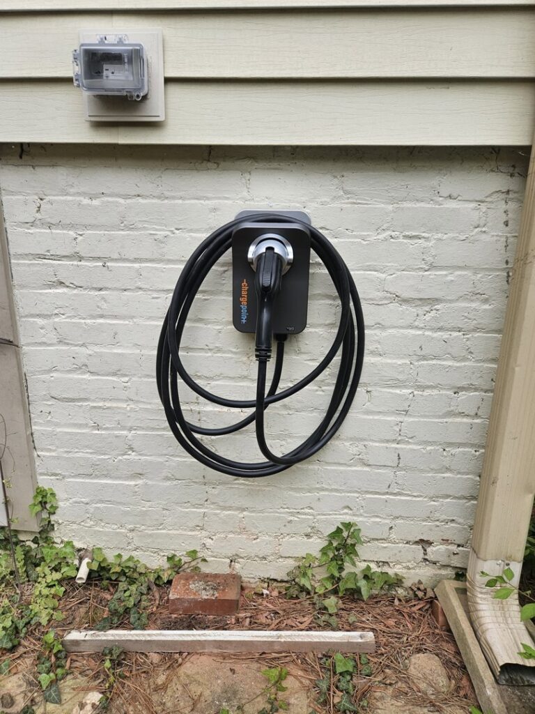 An electric vehicle (EV) charging station installed on an exterior brick wall by HLR Electric Company, LLC in Durham, NC.