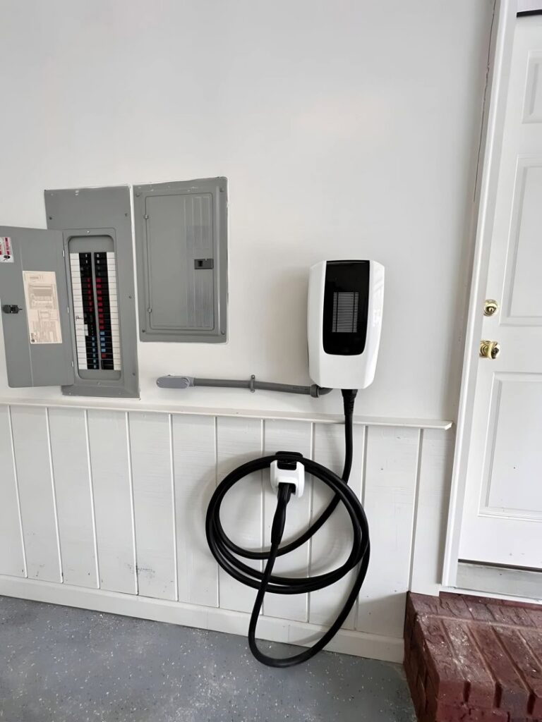 An EV charging station installed in a garage, connected to an electrical panel by Next Level Pros in Lakewood, CO.