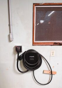 An Emporia EV charging station installed on a wall, a service provided by Titus & Son's Electric in Bluffton, IN.
