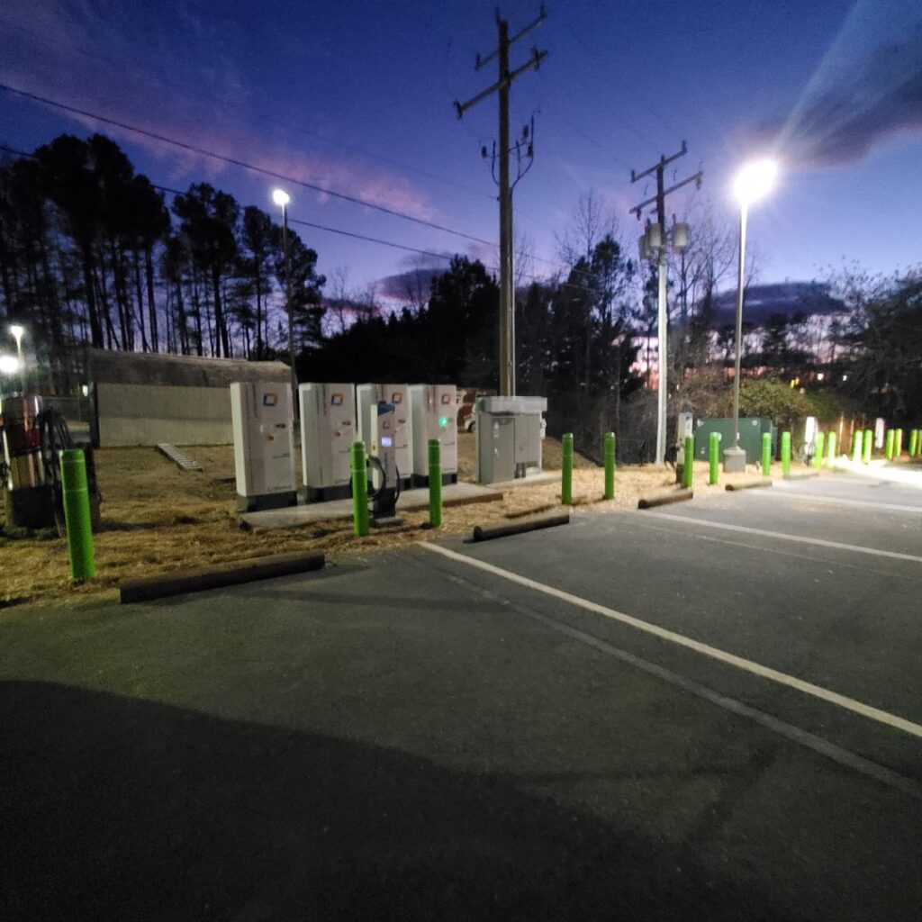 EV charging stations installed by Bay Electric Co. illuminated at night in Newport News, VA.