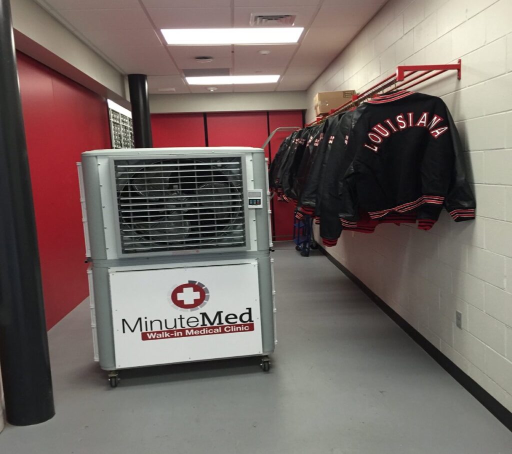 An evaporative cooler with MinuteMed branding in a clinic hallway by Cajun Kooling in Broussard, LA