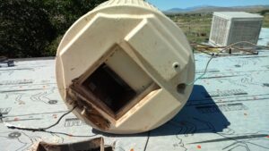 An old evaporative cooler being replaced with a new HVAC unit by Raytech Refrigeration, Heating & Cooling in Alamogordo, NM.