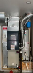 An Evcon HVAC furnace system with ductwork and a traditional water heater installed by AC Heating & Cooling in Meridian, ID.