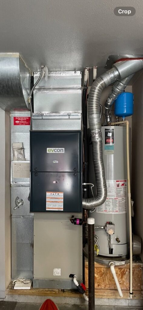 An Evcon HVAC furnace system with ductwork and a traditional water heater installed by AC Heating & Cooling in Meridian, ID.