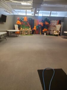 A large event hall with grey carpet and a cleaning hose, indicating professional service by Kingdom Kleen in Portsmouth, VA.