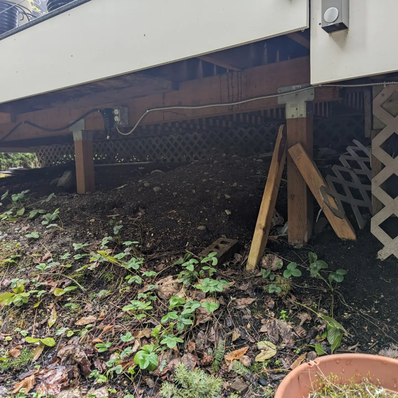 Existing electrical wiring and outlets visible under a residential deck, maintained by Alt Electric LLC in Federal Way, WA.