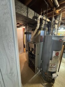 An existing furnace and water heater system in a utility room by HVAC KING LLC in Maple Grove, MN