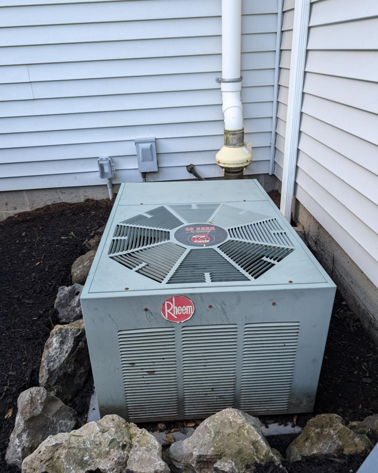 An existing Rheem outdoor AC unit, ready for service or replacement by Frank N Frank Mechanical Contractors in Rochester, NY.