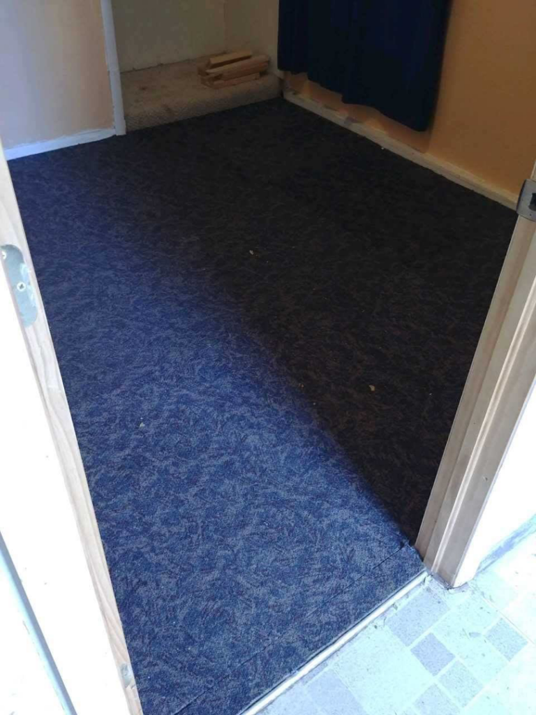 An existing patterned dark blue carpet in a room, ready for potential replacement or service by Carpet Direct of Northern Colorado in Loveland, CO.