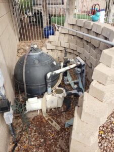 An existing pool equipment area with a pump and filter, ready for service by East Mesa Pools, LLC in Mesa, AZ.
