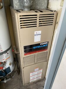An existing York Stellar furnace next to a water heater, ready for service by Heatwave Heating & Air LLC in Federal Way, WA.