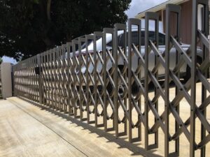 An expandable accordion-style driveway gate installed by KunkelWorks Hawaii in Mililani, HI.