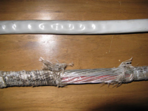 Close-up of exposed and damaged electrical cable, indicating a need for repair from Mac Electric Company in Warren, MI.