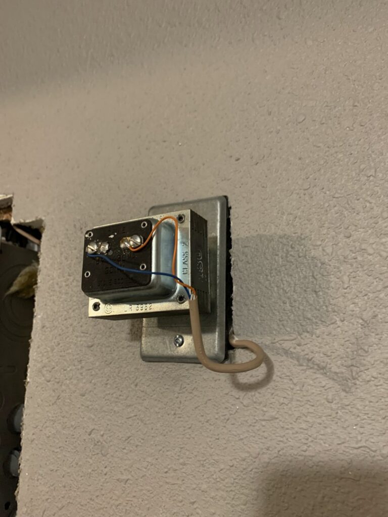 An exposed doorbell transformer installation on a wall by Interstate Electrical Contractors in Dalton Gardens, ID.