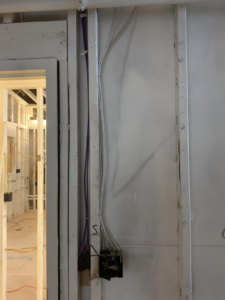 Exposed electrical cables and wiring in a framed wall during a project by Pacific Sun Electric in Oregon City, OR