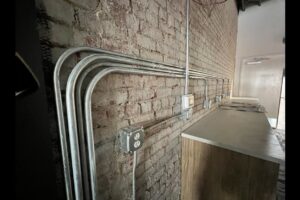 Exposed electrical conduit and outlets installed on a brick wall by Innovative Electric in Wichita, KS.