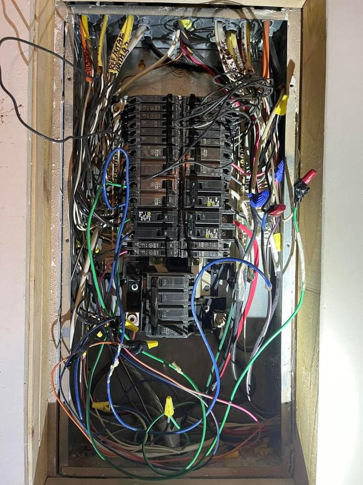 A detailed view of an exposed electrical panel with complex wiring and wire nuts by Plug It In Electric & more in Kansas City, MO.
