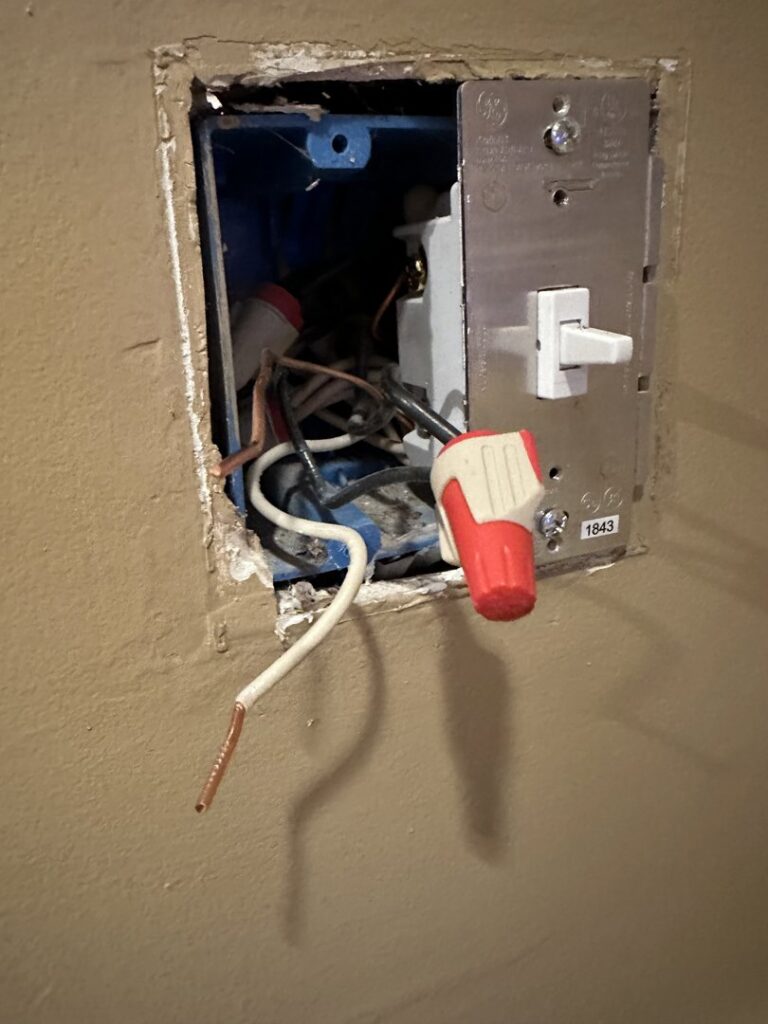 Exposed electrical wires and a light switch in an open wall box, showing electrical repair work by Murray Electric & Plumbing in Broken Arrow, OK.