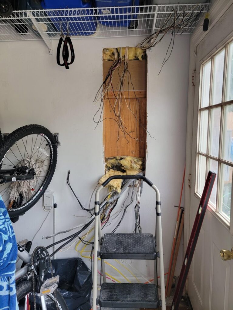 Exposed electrical wiring in a wall opening, indicating repair or installation work by Neptune Electric in Virginia Beach, VA.