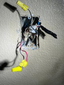 Exposed electrical wiring with wire nuts inside a wall box, demonstrating electrical work by AC-DC Electric in Severance, CO.
