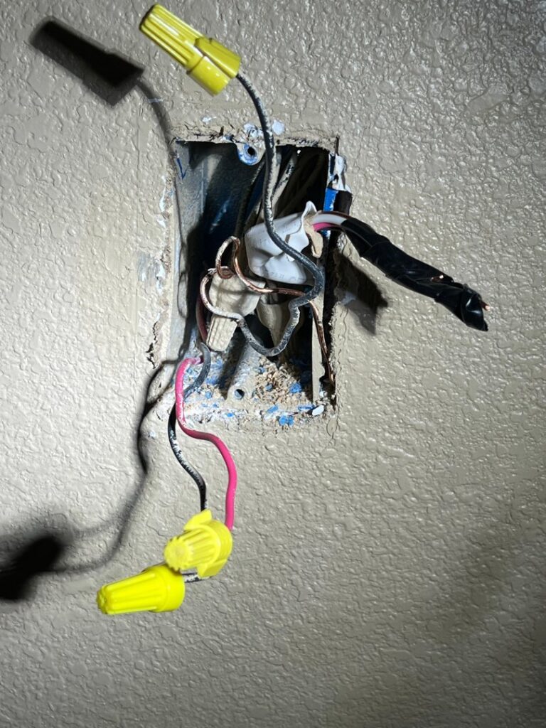 Exposed electrical wiring with wire nuts inside a wall box, demonstrating electrical work by AC-DC Electric in Severance, CO.